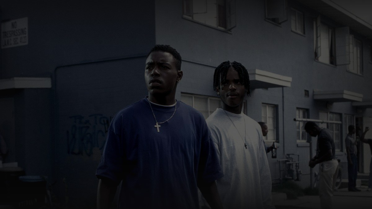 Still from Menace II Society (1993) — 16:9 still from letterboxd (1200x675, source luma 109.8), pre-darkened at 0.72, baked through scripts/bake_dark_photo.py at factor 0.45, output brightness 27.4